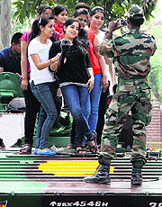A soldier click a photo of students standing atop a tank during an ongoing Army workshop at DAV college in Jalandhar on Saturday