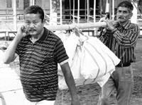 Workers carry election material for the elections to be held in Tezpur, on Saturday. PTI