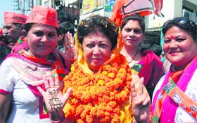 Lotus hand: Mala Raj Luxmi Shah, BJP candidate from the Tehri Lok Sabha seat, shows the party symbol made with mehndi during an election campaign in Dehradun on Sunday