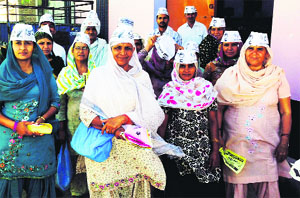 Gulab Kaur (second from left), wife of AAP candidate Jai Singh, is accompanied by AAP activists during her door-to-door canvassing in Gohana.