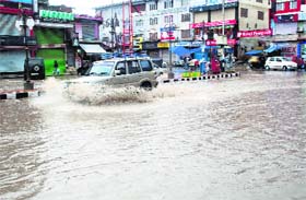 A vehicle wades through a waterlogged road in Srinagar on Sunday