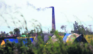 Smoke billows out of the chimney of a brick kiln on the outskirts of Jammu.