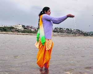 A woman offers prayers on Ashtami at the Tawi in Jammu on Monday.