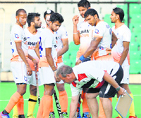 Indias chief coach Terry Walsh places a ball for a training drill as the players watch at a training session in New Delhi on Monday. Tribune Photo
