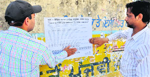 Members of the Unaided Staff Front paste a poster against Harsimrat Kaur Badal in Bathinda on Tuesday.