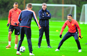 Manchester Uniteds manager David Moyes (2nd R) watches as Nemanja Vidic, Darren Fletcher and Ryan Giggs take part in a training session in Manchester on Tuesday, on the eve of their Champions League second leg quarterfinal against Bayern Munich.