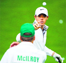 Rory McIlroy of Northern Ireland waits on the practice range with his caddie during a practice round prior to the start of the Masters Tournament in Augusta, Georgia, on Tuesday.