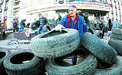 A pro-Russian activist reinforces a barricade in front of the Donetsk regional administration building with tyres on Tuesday