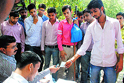 Election officials give money to Home Guards volunteers and students of Government College for having food at Sector 14 in Panchkula on Wednesday