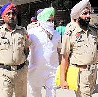 Policemen bring Ranjit Singh Rode, key accused in the shootout case, at the District Courts in Mohali