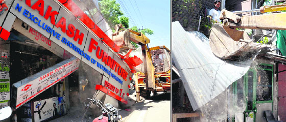A team of the district administration removes illegal structures from Chakrata Road in Dehradun on Wednesday.