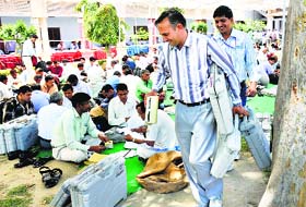 Poll officials prepare to leave for their repective polling stations from an EVM distribution centre in Karnal on Wednesday