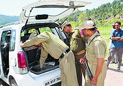 Policemen check a car abandoned by militants in Jammu on Wednesday