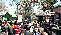 People wait outside the Deputy Commissioner's office as their entry was restricted in Srinagar on Wednesday