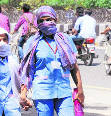 Girls cover their face to escape the sun in Bathinda on Thursday.