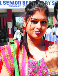A first-time voter shows her inked finger after casting her vote. 