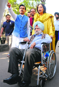 BJP candidate Kirron Kher helps her 101-year-old father, Col Thakar Singh (retd), to a polling booth in Sector 8.