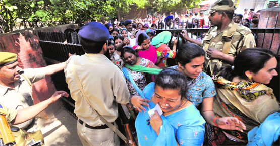 Voters fight their way through a gate at a polling station in Indira Colony, Mani Majra. 