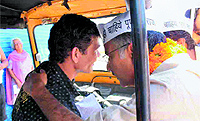 Anoop Nautiyal, AAP Tehri Lok Sabha seat candidate, interacts with an auto driver in Dehradun on Thursday