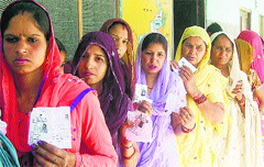 Women await their turn at a polling booth in Kaithal on Thursday. Photo: Satish Seth