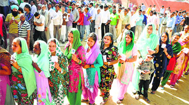 Residents wait for their turn to cast their votes at the Gorakh Nagar polling station