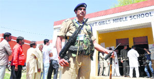 A security personnel outside a polling station at Gurha Bramahna village in Akhnoor on Thursday