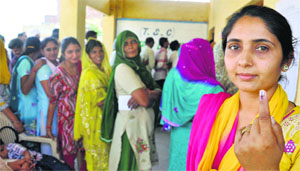 A voter shows her ink-marked finger after casting her vote at suchetgarh village in Jammu on Thursday