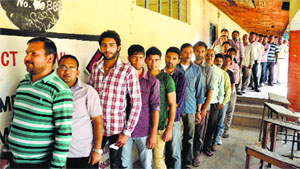 Voters wait in a queue outside a polling station in Akhnoor city on Thursday. 