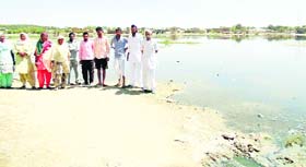 Residents of Kali Basti in Abohar standing near a pond stored with dirty water that is a threat to their health.