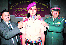 Saurabh Kumar, honorary secretary of Sainik Schools Society, and Col Devesh Gaur confers an epaulette on a students shoulder at Sainik School, Ghorakhal, in Dehradun on Friday