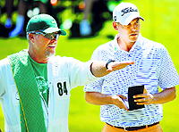 Bill Haas (R) and his caddie Scott Gneiser discuss a putt on the 16th hole during the first round of the Masters golf tournament at Augusta on Saturday