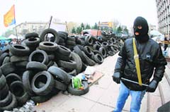 Pro-Russian protester guards a barricade outside the regional state administration building in Donetsk on Friday. AFP