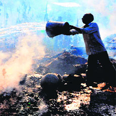 A man tries to douse the fire as flames engulf dozens of houses at Sapt Sarovar colony in Haridwar on Saturday.