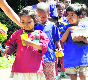 Street children being given food during a programme by various NGOs to mark the International Day for Street Children at Gandhi Park in Dehradun on Saturday.