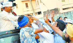 Supporters greet AAP convener Arvind Kejriwal during his road show in Ludhiana on Saturday. Tribune Photo: Himanshu Mahajan