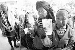 Women voters show their I-cards as they wait in a queue at a polling station at Dhamcherra in Tripura on Saturday. PTI 