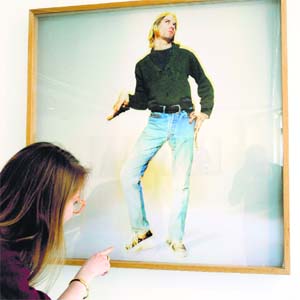 A woman looks at a photo of late singer Kurt Cobain, as part of the exhibition "The Last Shooting" at the Addict gallery in Paris