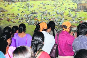 Visitors have a look at a picture showing the dead bodies of martyrs killed in the massacre