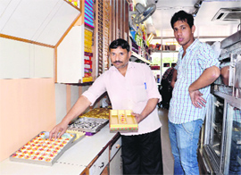 A worker of Bhawani Misthan Bandar on Bibiwala Road shows the sweets prepared on Sunday.