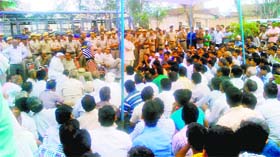 Police personnel and villagers hold a meeting to defuse the tension at Punhana village in the Mewat area of Gurgaon on Sunday
