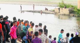 Residents gather on the banks of the Sutlej as divers search for the body of a youth in Ludhiana on Sunday.