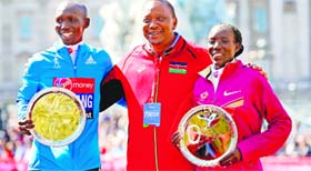 The winners of both the mens and womens London Marathon, Kenyans Wilson Kipsang (L) and Edna Kiplagat (R), pose with Kenyas President Uhuru Kenyatta on Sunday.