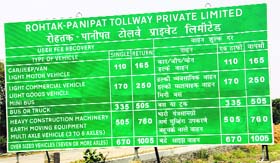 A signboard displaying the toll rates at the Makdauli village toll plaza.