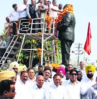 As the BJP leaders walk up to garland the statue of Dr BR Ambedkar, Congress candidate Chaudhary Santokh Singh and his supporters pose for a picture after the ceremony on the occasion of Ambedkar Jayanti in Jalandhar on Monday. Photo: Sarabjit Singh