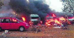 Vehicles burn after twin blasts at a bus station in Abuja on Monday. AFP