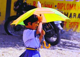 Seeking respite: A girl uses an umbrella to protect herself from the rise in temperature as she returns from school in Dehradun on Tuesday