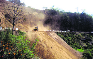 Machinery throws debris into the slope by the national highway at Jarol near Sundernagar on Tuesday. 