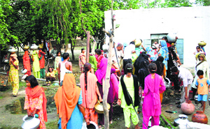 Residents of Kolwas village fetch water from a hand pump.