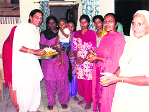 A transgender distributes sweets among neighbours in Barsin village of Fatehabad on Tuesday.