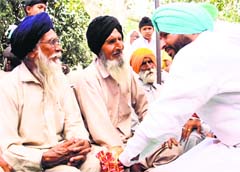 Congress candidate Ravneet Singh Bittu interacts with senior citizens at a village on Tuesday. A Tribune photograph